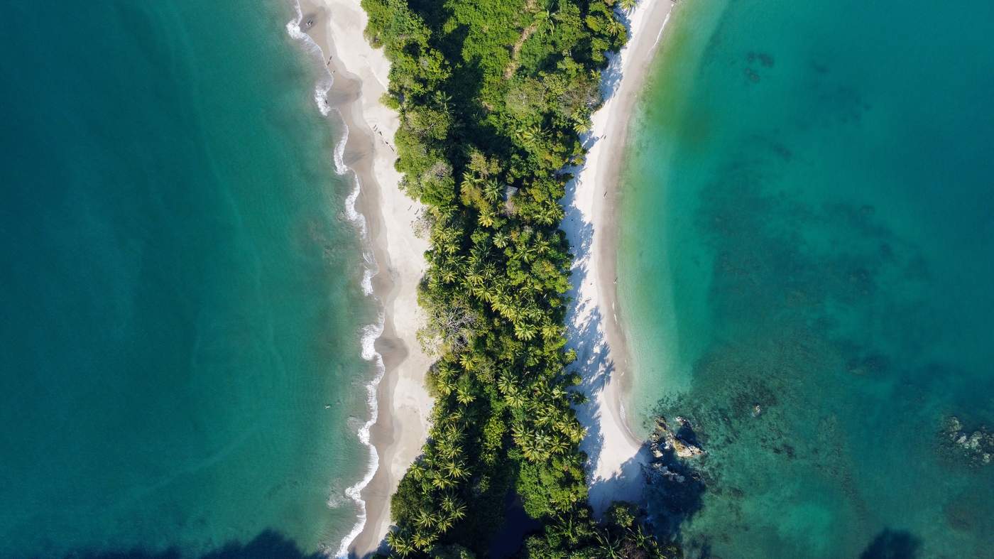 Aerial view of a jungle peninsula between two turquoise coastlines
