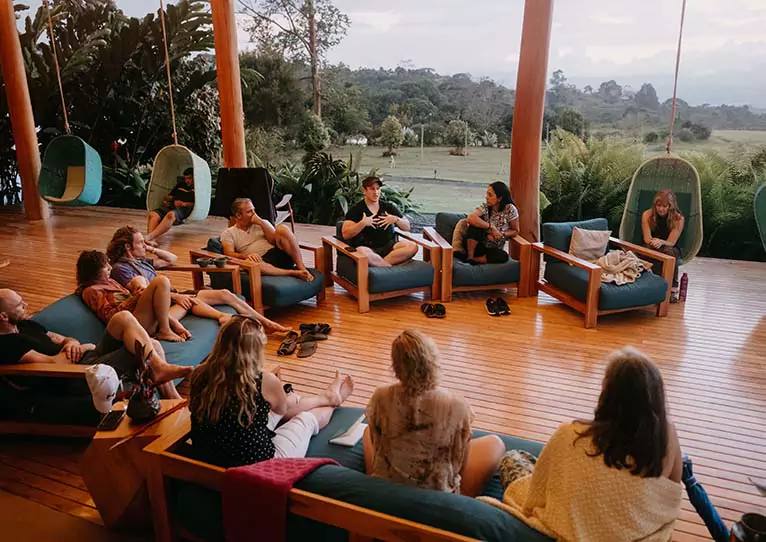 A group in conversation on an open-air wooden deck