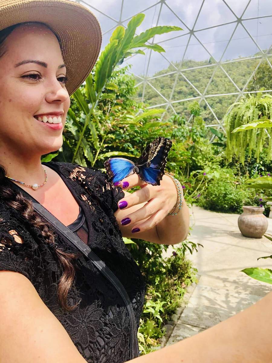 Sara smiling with a blue morpho butterfly on her hand