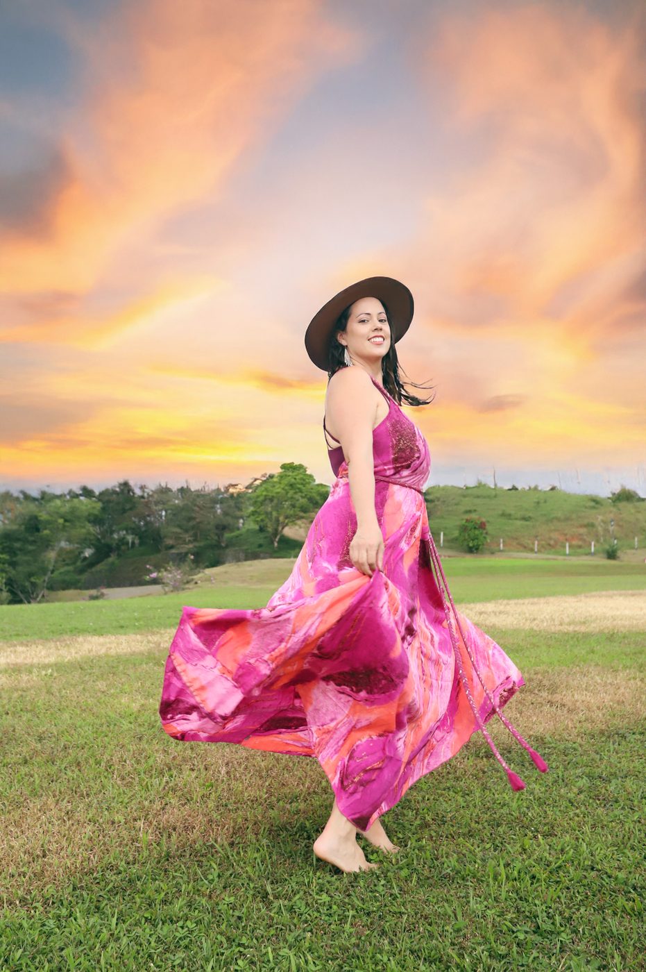 Sara, founder of Avia Collective, in a pink dress at sunset