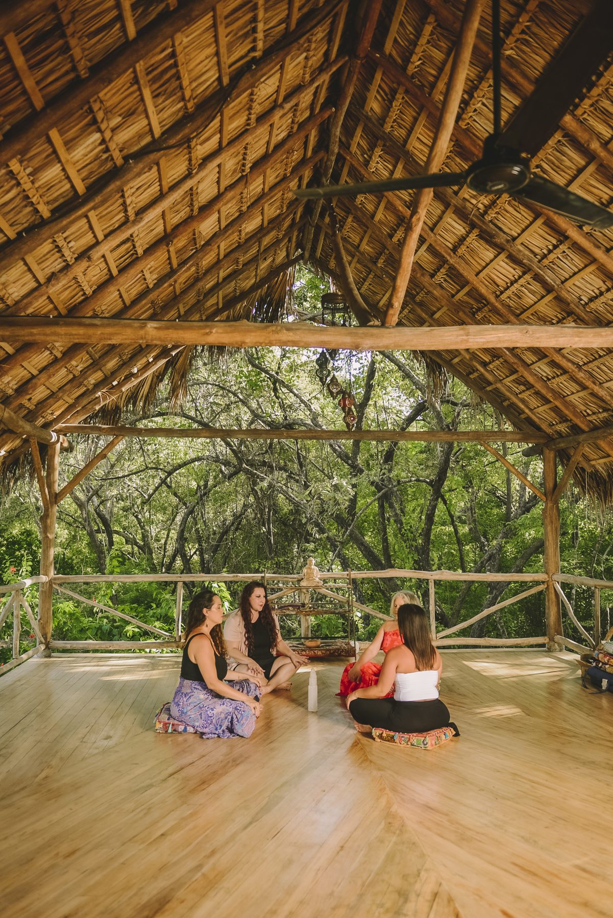 A circular open-air yoga pavilion over water, ready for a group to gather