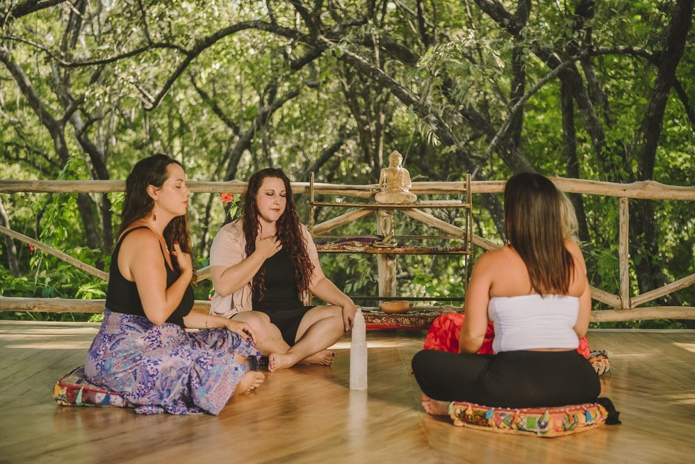 Women in a seated ceremony circle in the forest
