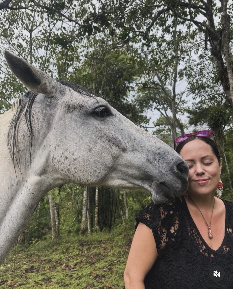 A woman resting her head against a horse