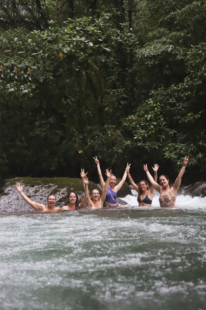 A group of women celebrating in a jungle river