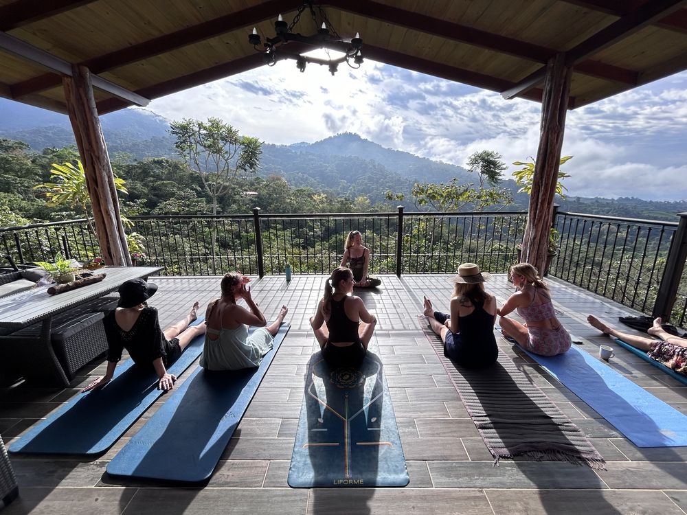 A group practicing yoga on a deck overlooking the mountains